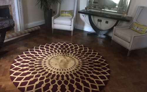Hand tufted red circle rug with gold spirograph like design